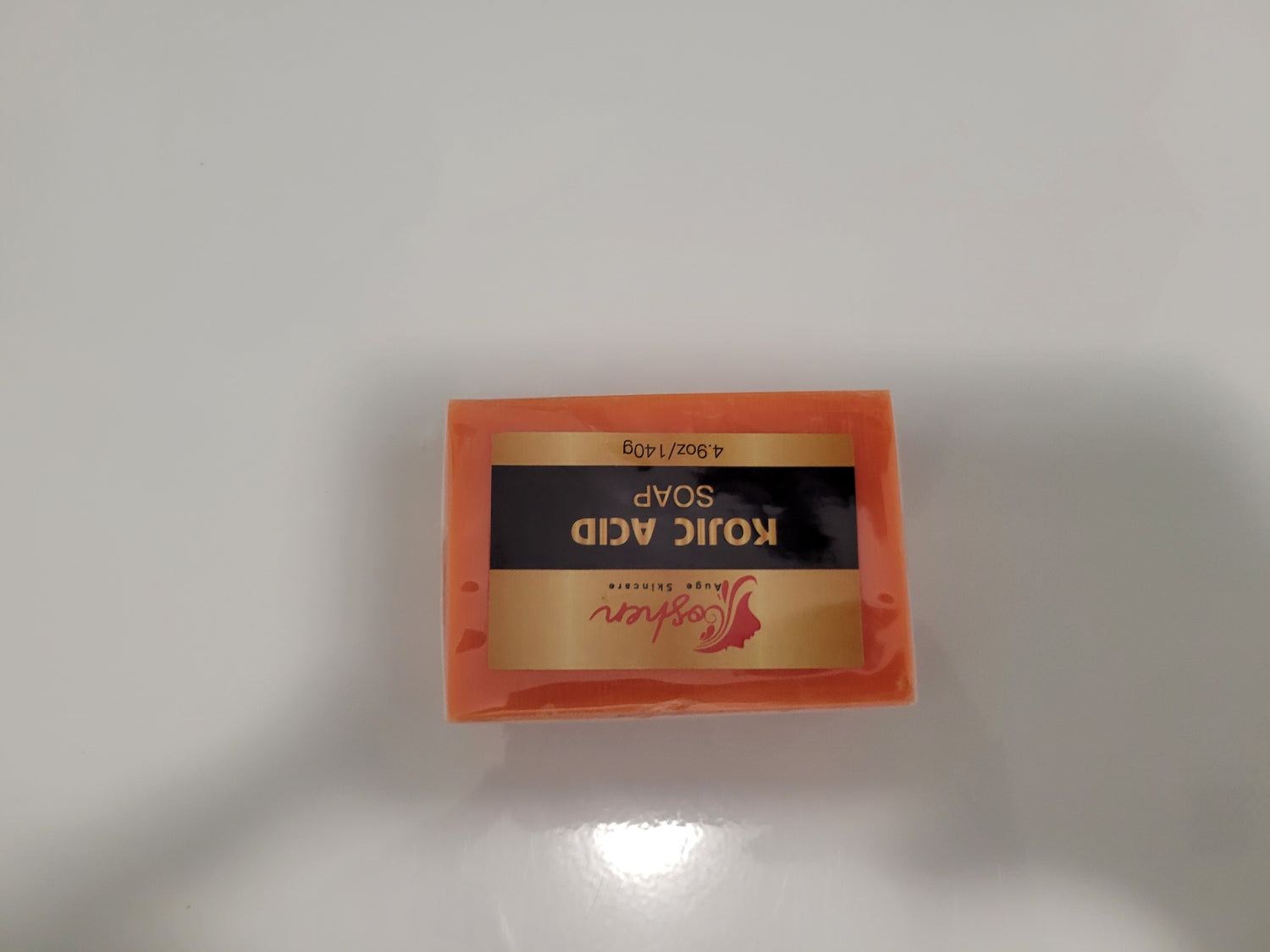 Kojic Acid Soap bar with label showing the product name and weight on a white surface.